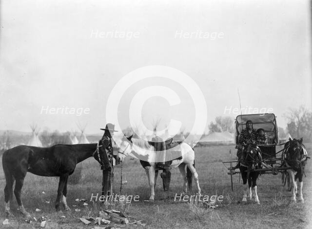 High Medicine Rock, Crow Indian with two horses at left, Her Horse Kills with child in..., c1908. Creator: Edward Sheriff Curtis.