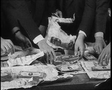 American Police Officers Counting Money Found in Relation To the Lindbergh's Kidnapping Case, 1930s. Creator: British Pathe Ltd.