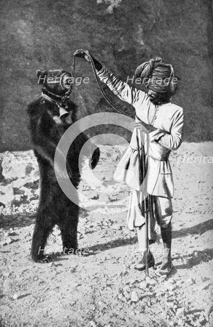 A Punjabi native with a dancing bear, India, 1922.Artist: Robert Chisham