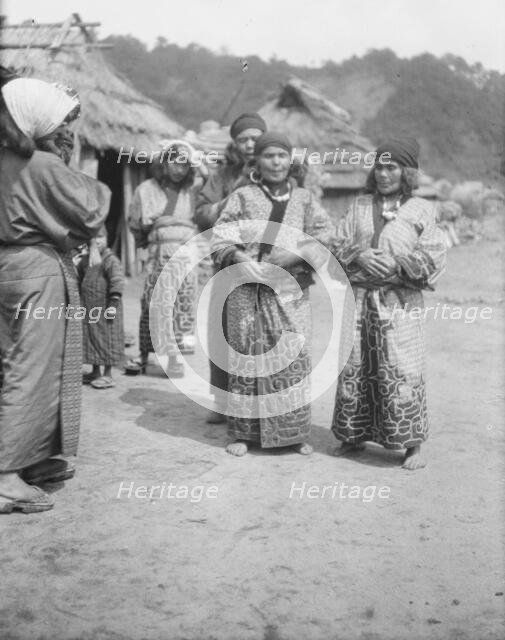Ainu woman outside in the village lane, 1908. Creator: Arnold Genthe.