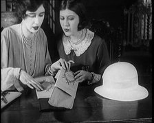 Two Female Civilians Cutting  Sheets of Paper to Decorate a Hat, 1920. Creator: British Pathe Ltd.