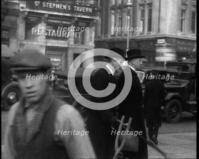 Two Male Politicians Walking Along a Busy Bridge Street Towards the Palace of Westminster, 1937. Creator: British Pathe Ltd.