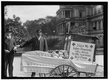Peanut vendor Steve Vasilakas standing near his cart..., between 1916 and 1918. Creator: Harris & Ewing.