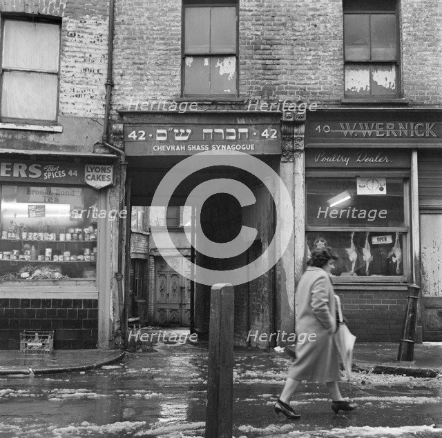 A woman walks past the Chevrah Shass Synagogue, Whitechapel, London c1946-c1959. Artist: John Gay