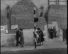 British People Walking by Heavily Sandbagged Buildings, 1940. Creator: British Pathe Ltd.