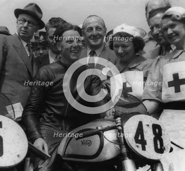 Geoff Duke on Norton, with nurses after race in 1951. Creator: Unknown.