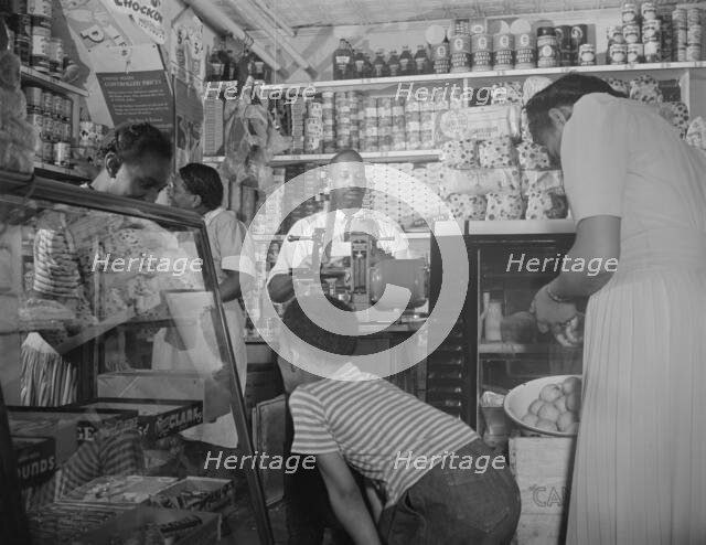 Grocery store owned by Mr. J. Benjamin, on Saturday afternoon, Washington, D.C., 1942. Creator: Gordon Parks.