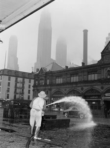 City sanitation workman washing streets at Fulton fish market, New York, 1943. Creator: Gordon Parks.