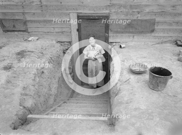 Mrs. Free in doorway of her basement dugout home, Dead Ox Flat, Oregon, 1939. Creator: Dorothea Lange.