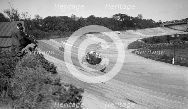 Eddie Hall's Bentley leading a Bugatti on the banking at Brooklands.   Artist: Bill Brunell.