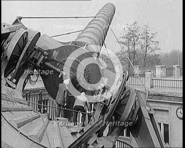 Large Telescope Being Turned by Two Civilians, 1931. Creator: British Pathe Ltd.