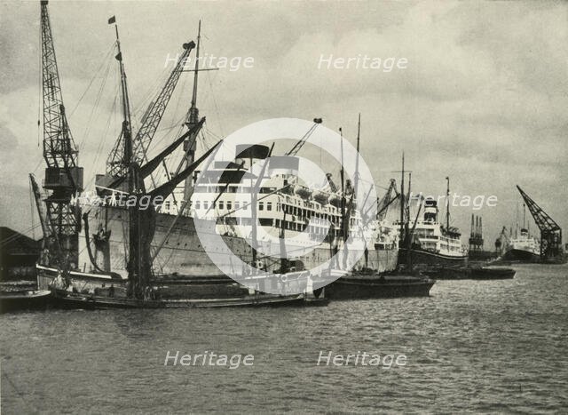 "The Forest of Masts Has Given Place to a Cluster of Steamer Funnels" Vessels Berthed at...', 1937. Creator: Unknown.