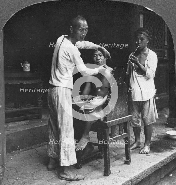 A Chinese barber at Bhamo, Burma, 1908. Artist: Stereo Travel Co
