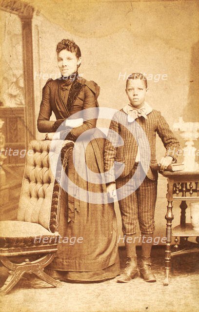 Unidentified standing figures: woman, her folded arms leaning on back of chair..., 1890. Creator: J. N. Wilson.