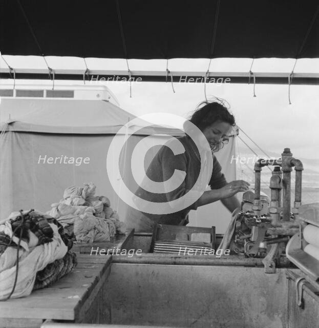 Young migrant girl makes use of facilities..., Merrill FSA camp, Klamath County, Oregon, 1939. Creator: Dorothea Lange.