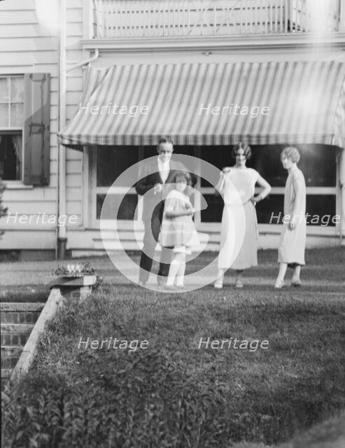Dunning family, standing outside house, 1925 July 9. Creator: Arnold Genthe.