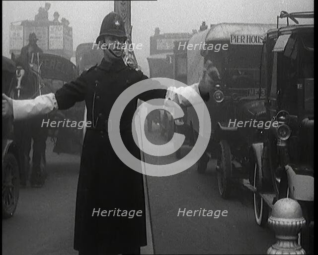 Male British Police Officer Controlling the Traffic On the Streets of London, 1920s. Creator: British Pathe Ltd.