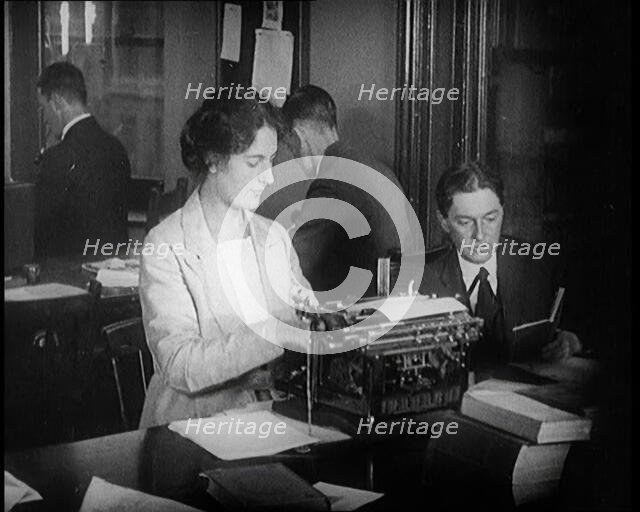 Journalists at Work Typing, Reading, and Making Notes. a Woman Is Typing What Is Being..., 1921. Creator: British Pathe Ltd.