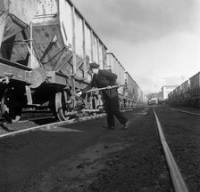 Final adjustments to a rail truck hauling coal from Lynemouth Colliery, Northumberland, 1963.  Artist: Michael Walters