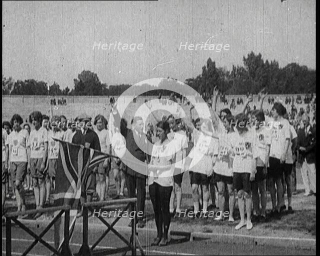 Female British Olympic Athletes Doing the Olympic Salute at the Women's World Games, 1922. Creator: British Pathe Ltd.