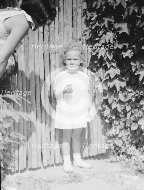 Mrs. Carl Muschenheim and daughter, standing outdoors, 1933 Aug. Creator: Arnold Genthe.