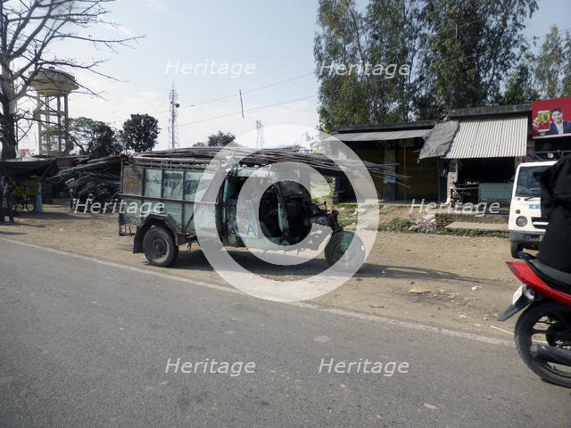 Tutuk carrying load of steel rods on roof, India 2017. Creator: Unknown.