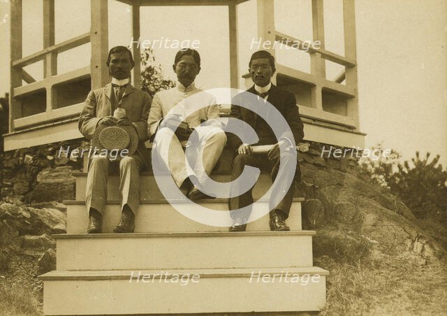 Three Japanese men, possibly journalists, seated on the steps of a gazebo, 1905. Creator: Unknown.