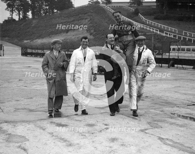 Leon Cushman being carried aloft after making a successful speed record attempt, Brooklands, 1931. Artist: Bill Brunell.