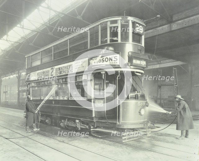 Transport workers washing a tram at the Holloway Car Shed, London, 1932.  Artist: Unknown.