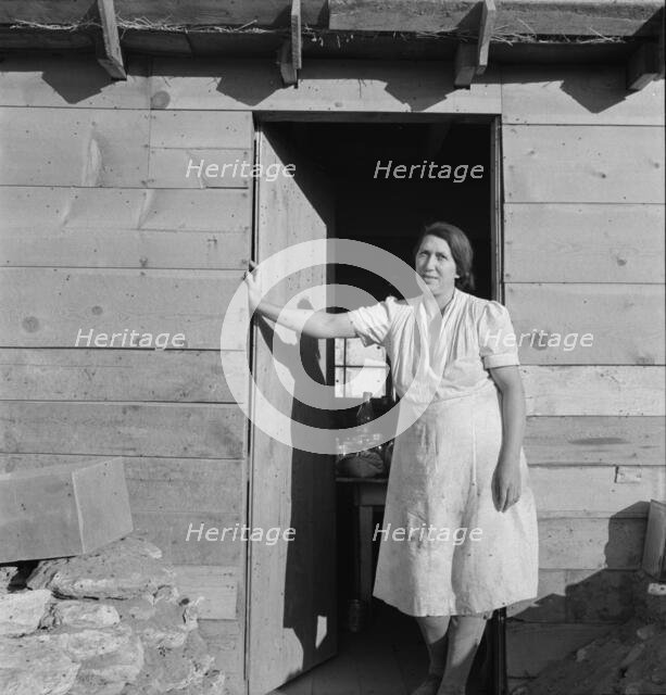 Mrs. Dougherty in doorway of basement house, Warm Springs, Malheur County, Oregon, 1939. Creator: Dorothea Lange.