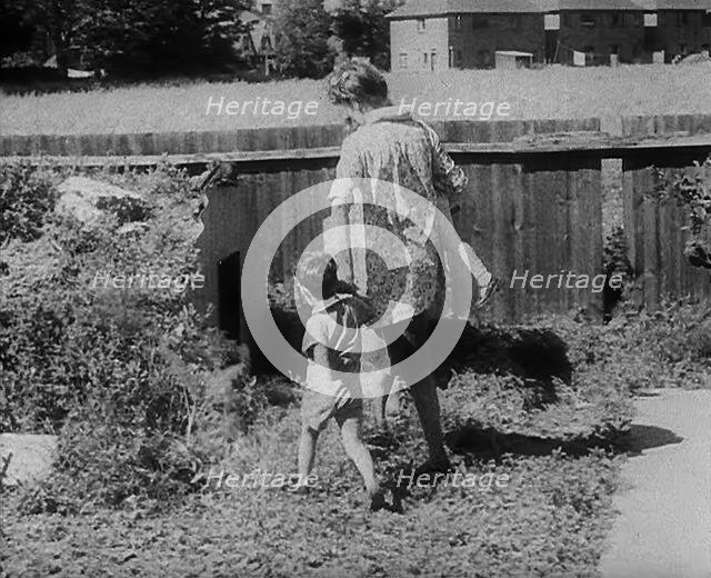 Woman Leading Her Children to an Air Raid Shelter, 1940. Creator: British Pathe Ltd.