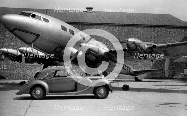 1938 Lagonda V12 4.5 litre drophead coupe with D.H. Albatross aeroplane Artist: Unknown.