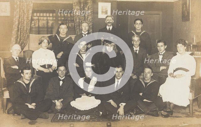 Sailors, some in drag, posing for a group portrait within a highly...(between 1910 and 1919?). Creator: Unknown.