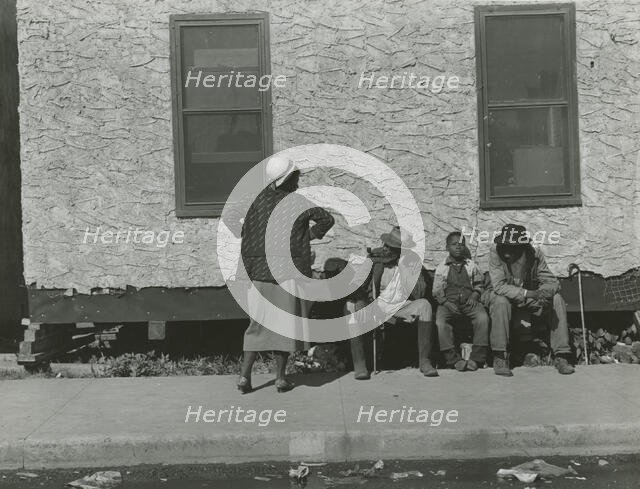 Two African American men and one African American boy sitting and one African..., Jan 1939. Creators: Farm Security Administration, Marion Post Wolcott.