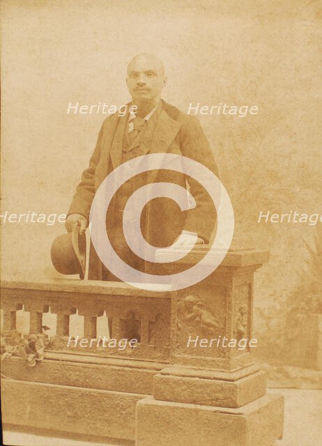 Studio portrait of man dressed in suit and coat, holding bowler hat, c1890. Creator: Steinhardt.