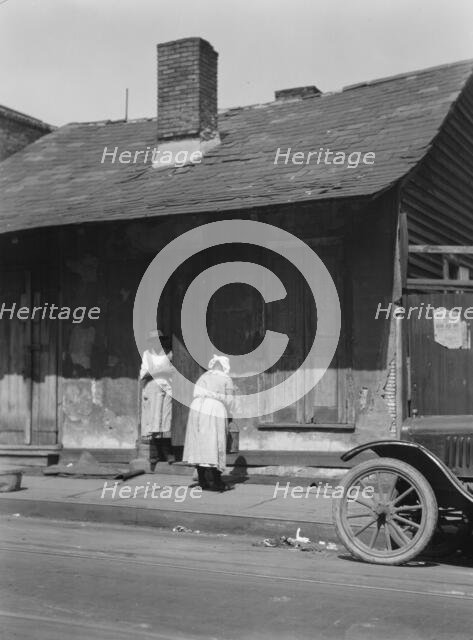 Two women standing in or by a doorway, New Orleans, between 1920 and 1926. Creator: Arnold Genthe.