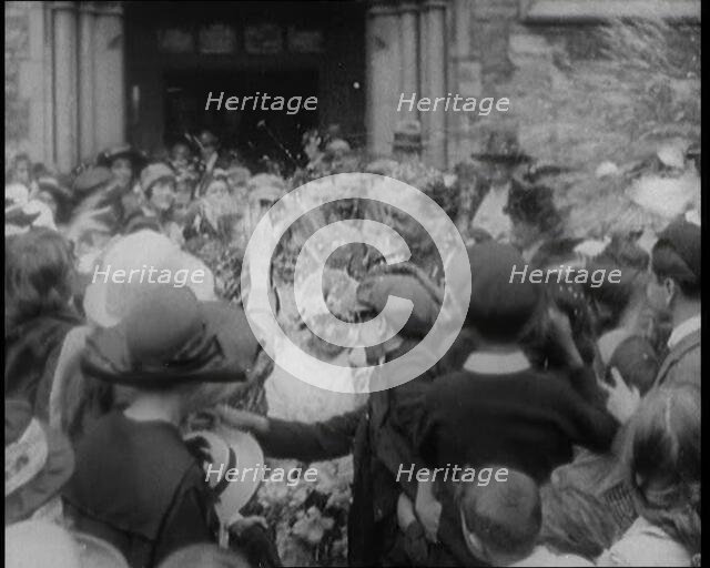 British Bride and Groom Exiting a Church After Their Wedding Ceremony. Guests Are Throwing..., 1921. Creator: British Pathe Ltd.