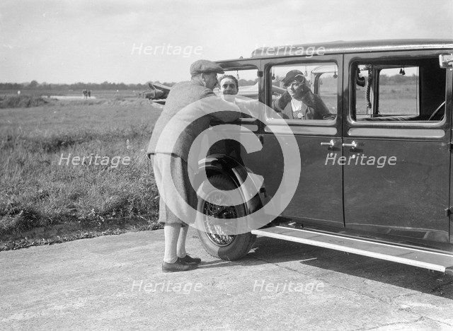 Hugh McConnell, Sammy Davis and Mrs Davis with an Austin 20/6 landaulette at Brooklands, 1931. Artist: Bill Brunell.