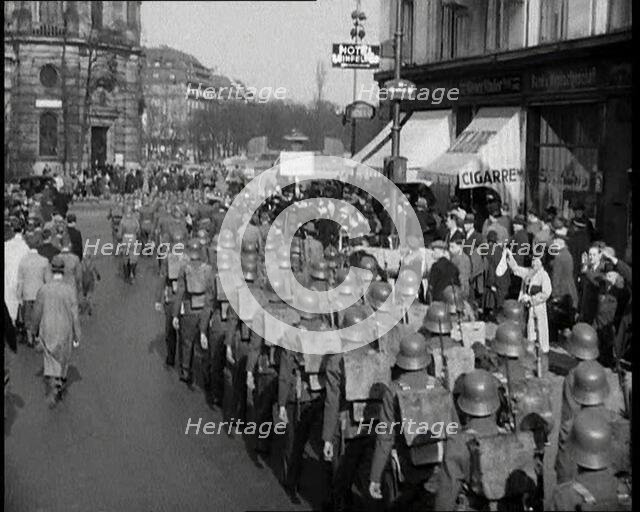 Crowd Watching German Soldiers Marching Down a Street Away from the Camera, 1930s. Creator: British Pathe Ltd.