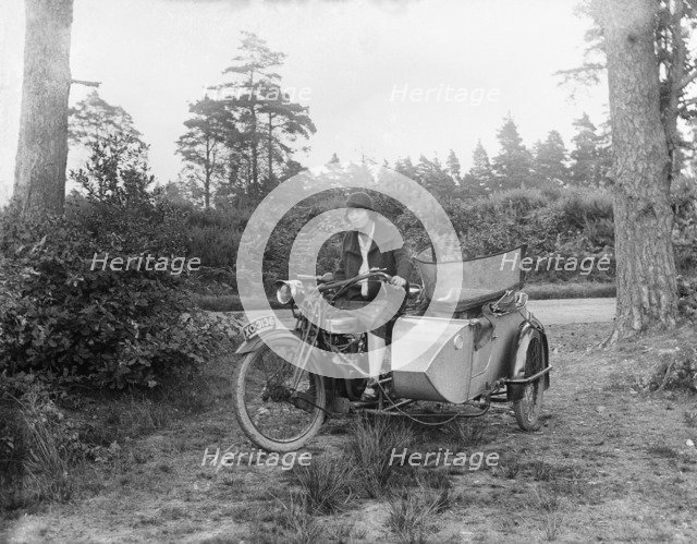 A woman riding a Douglas flat-twin motorcycle with a sidecar, 1900-1910. Artist: Unknown.