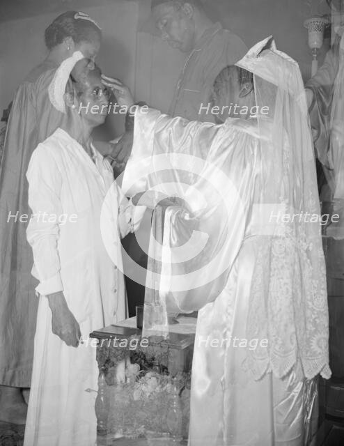 Mrs. Ella Watson, a government charwoman, receiving annointment..., Washington, D.C., 1942. Creator: Gordon Parks.
