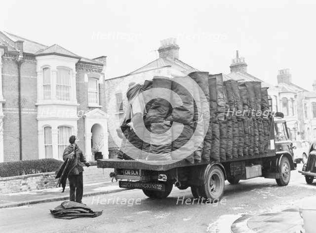 Charringtons delivering sacks of coal down a residential street. Artist: Unknown
