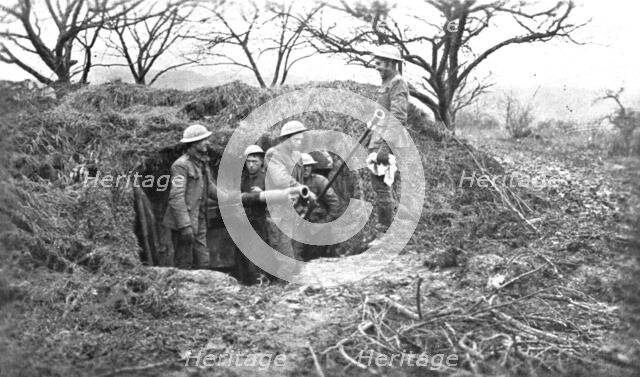 'Les Americains en Ligne; Une piece de 75, sous son camouflage, et ses servants americains', 1917 . Creator: Unknown.