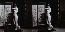 A young woman posing naked in a photographic studio, leaning on the back of a chair..., c1900. Creator: Unknown.