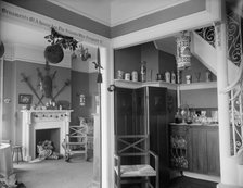 Hallway with liquor cabinet and living room decorated with mistletoe ball and Christm..., c1900-1915 Creator: Unknown.