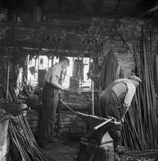 Men working in a blacksmith's workshop, c1946-c1959. Artist: John Gay