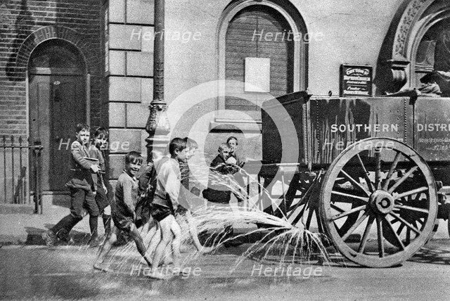 Boys following the Poplar Borough Council water cart, London, 1926-1927. Artist: Unknown