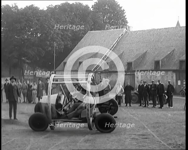 A Crashable Car With a Circular Frame Allowing It To Roll Over Being Tested in Front of..., 1926. Creator: British Pathe Ltd.