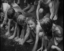 Children Splashing in Water in the Gutter During a Heatwave in New York City, 1921. Creator: British Pathe Ltd.