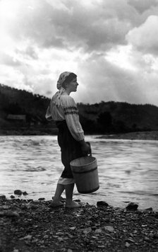 Young woman with a bucket, Bistrita Valley, Moldavia, north-east Romania, c1920-c1945. Artist: Adolph Chevalier